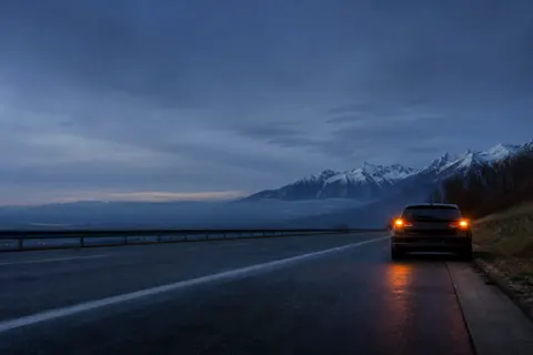 Voiture immobilisée sur bande d’arrêt d’urgence d’autoroute de montagne, feux de détresse — procédure SOS SkyRoute Auto